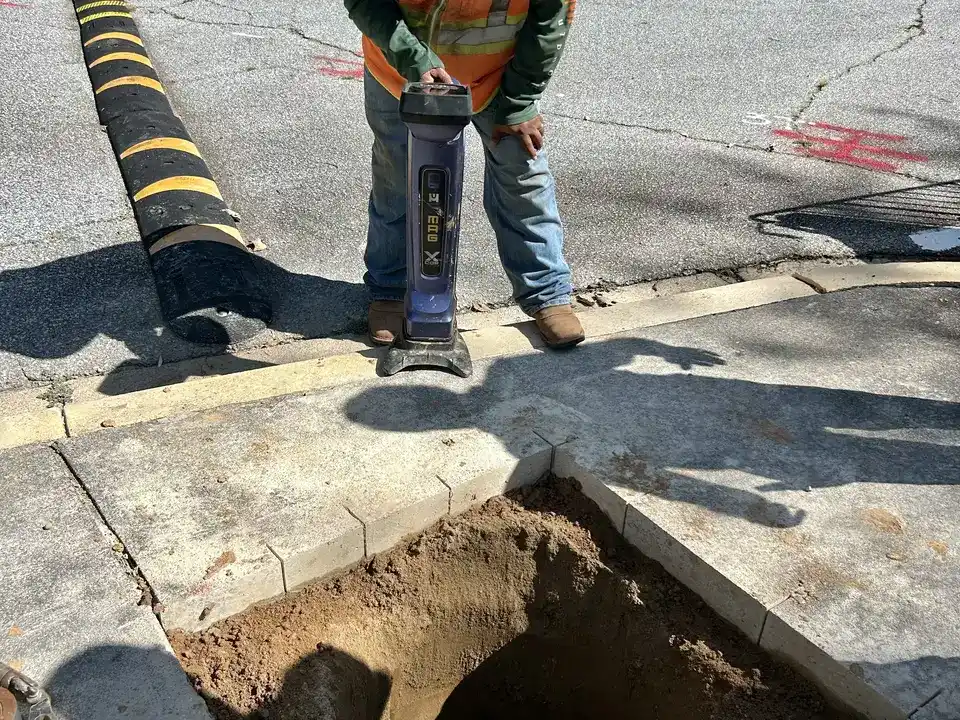 Square-cut tie-in pit in a Greenville, SC commercial parking lot &mdash; the only surface opening a trenchless bore needs