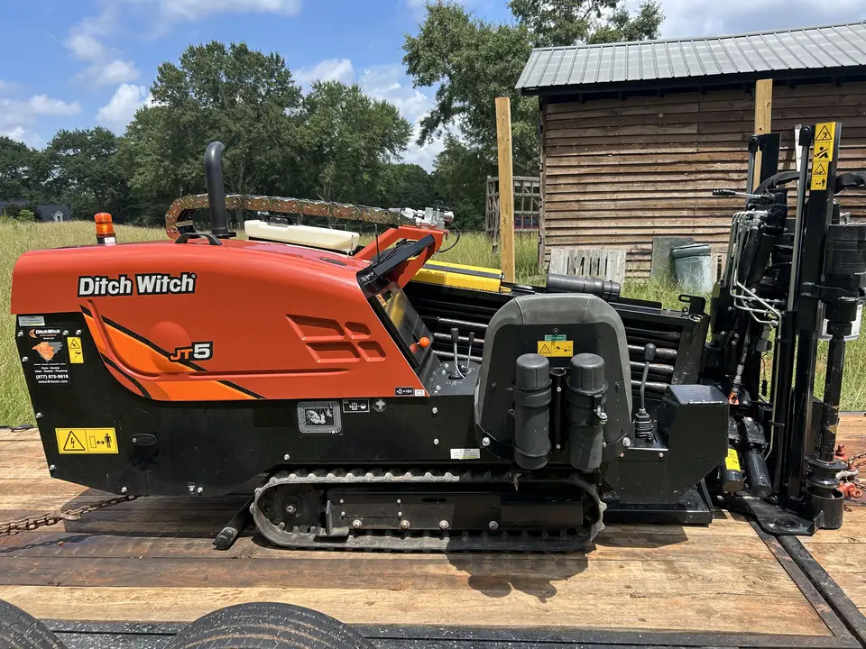 Ditch Witch JT5 directional drill staged beside a barn on a rural Greenville County, SC property before a residential utility bore
